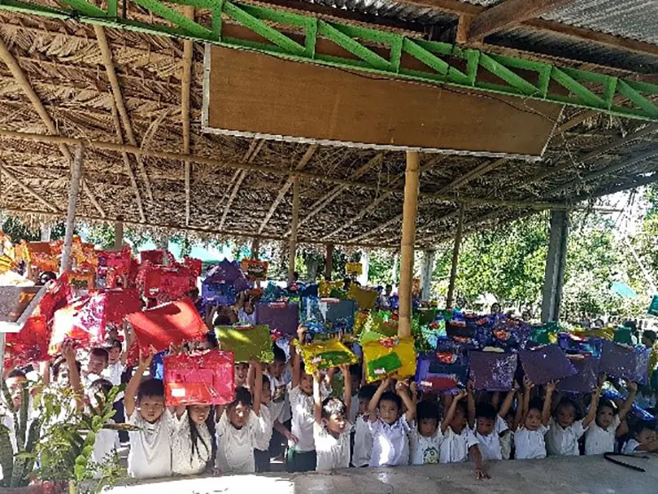 The Cabulihan Elementary kids waving their sets of school supplies from Sales Rain The Cabulihan Elementary kids waving their sets of school supplies from Sales Rain